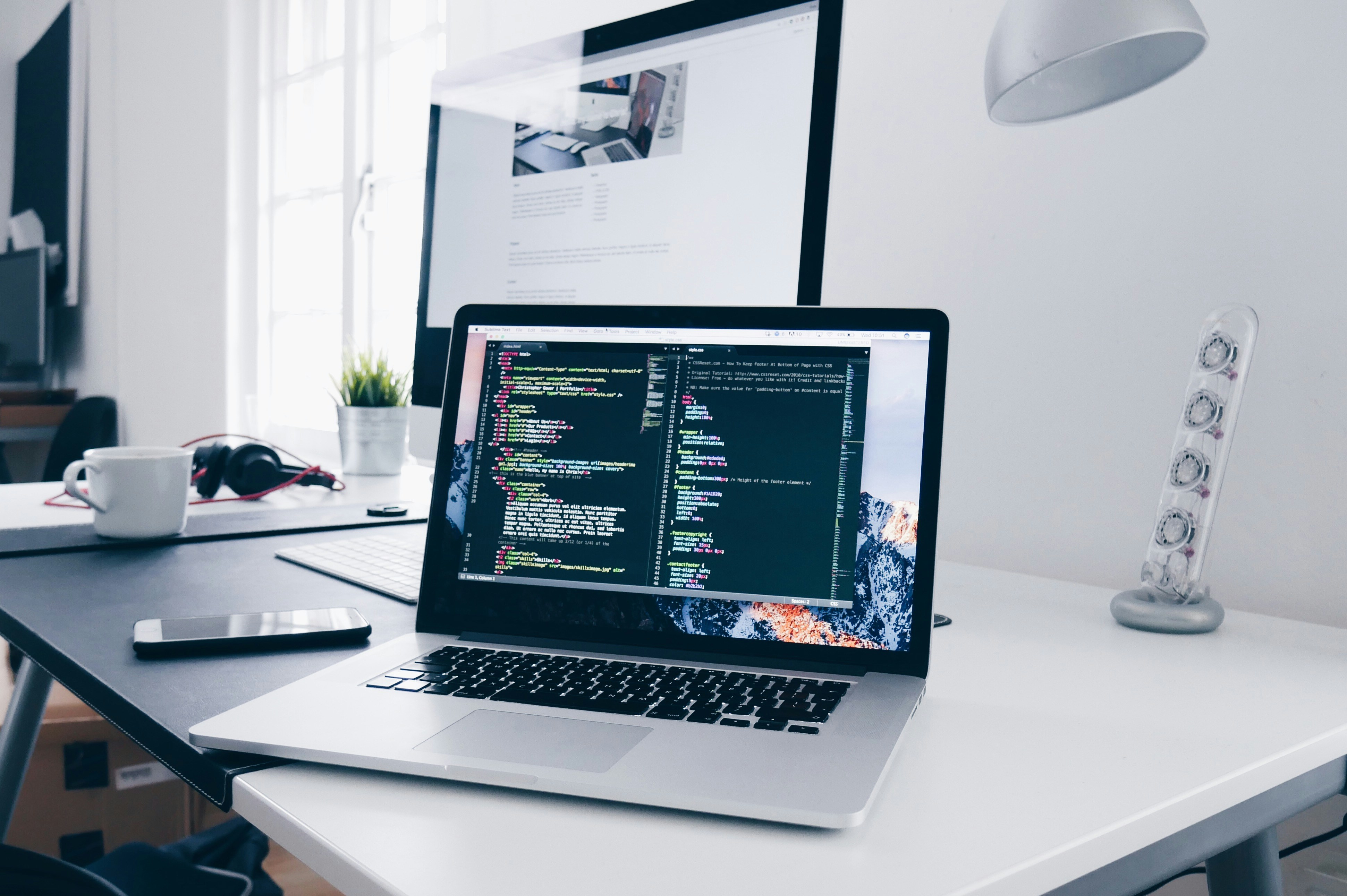 A Terra ICT engineer's workspace — a laptop showing live infrastructure code beside a monitor